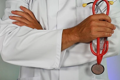 doctor holding a stethoscope with his arms crossed